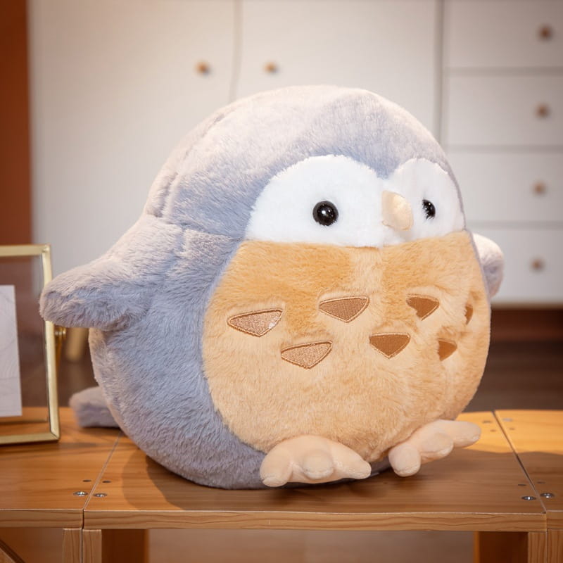 Soft gray and beige plush owl stuffed animal with embroidered black eyes tan beak and triangular cutouts on its belly designed as a round soft doll toy.