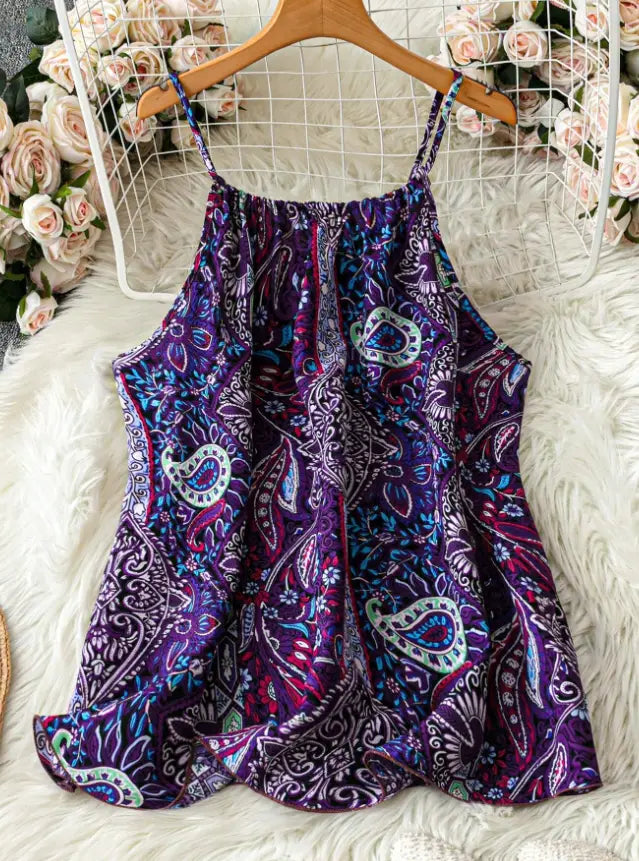 Top sin mangas con estampado de corazón para tallas grandes, con un diseño sin mangas con patrón de cachemir morado y azul, tirantes finos, colgado de una percha de madera.