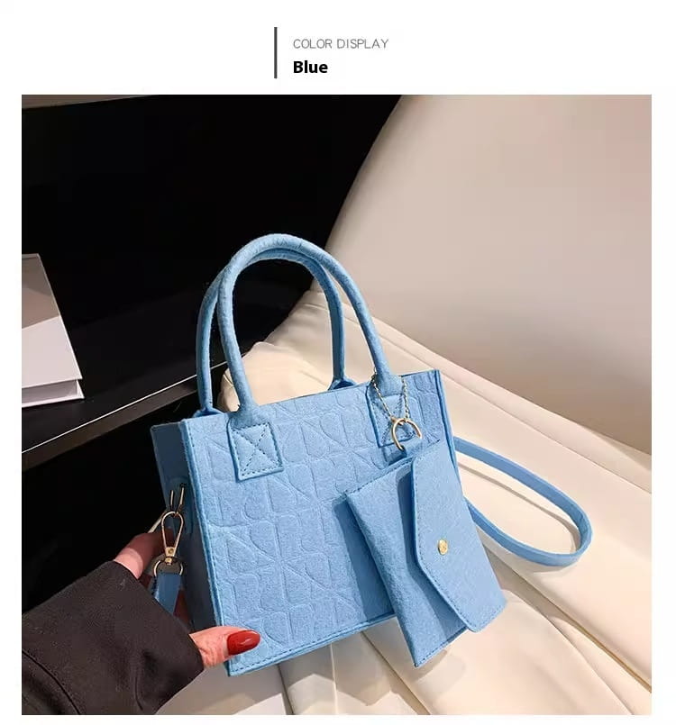 Eine hellblaue Mini-Handtasche aus wattiertem Filz mit passendem abnehmbarem Träger und goldfarbenen Beschlägen, dargestellt in einem Handtaschen-Set mit passender Geldbörse.