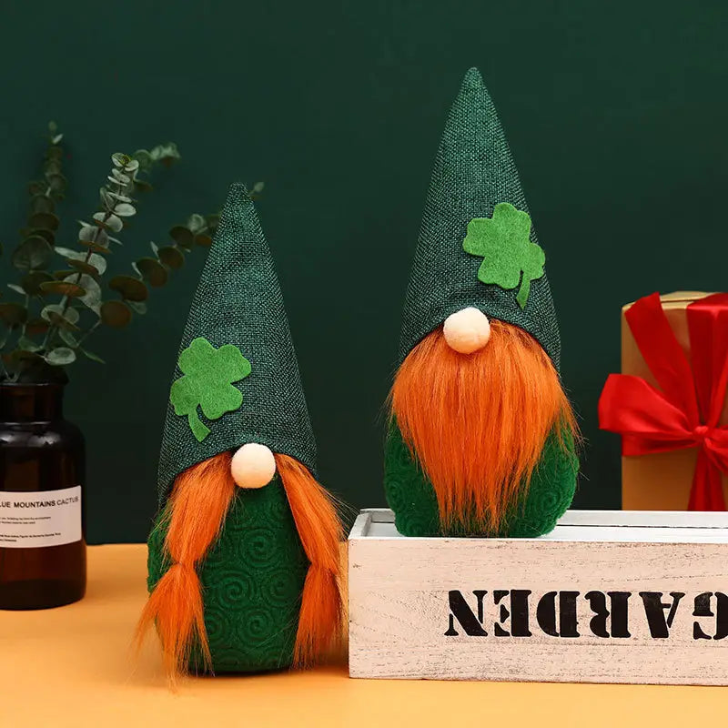 Zwei St.-Patrick’s-Day-Leprechaun-Gnome-Plüschpuppen aus grünem Filz mit orangefarbenen Bärten und Kleeblatt-Dekorationen auf ihren Hüten.
