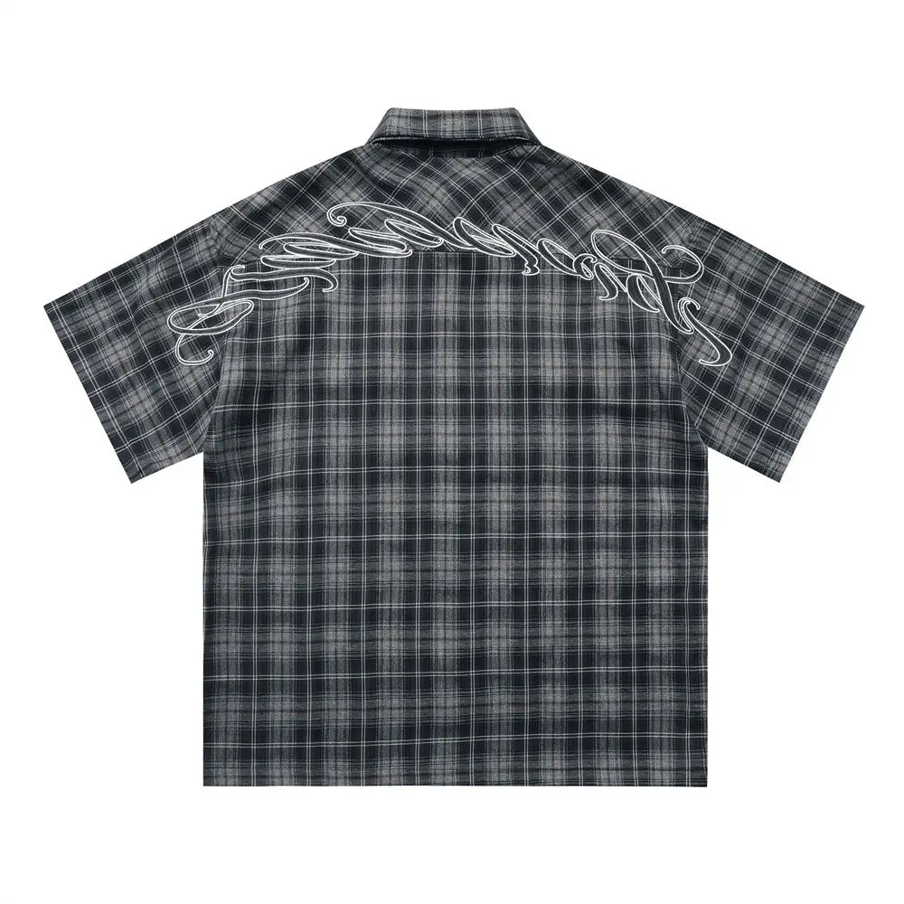 Black and gray plaid short sleeve shirt with white embroidered script on the back side.