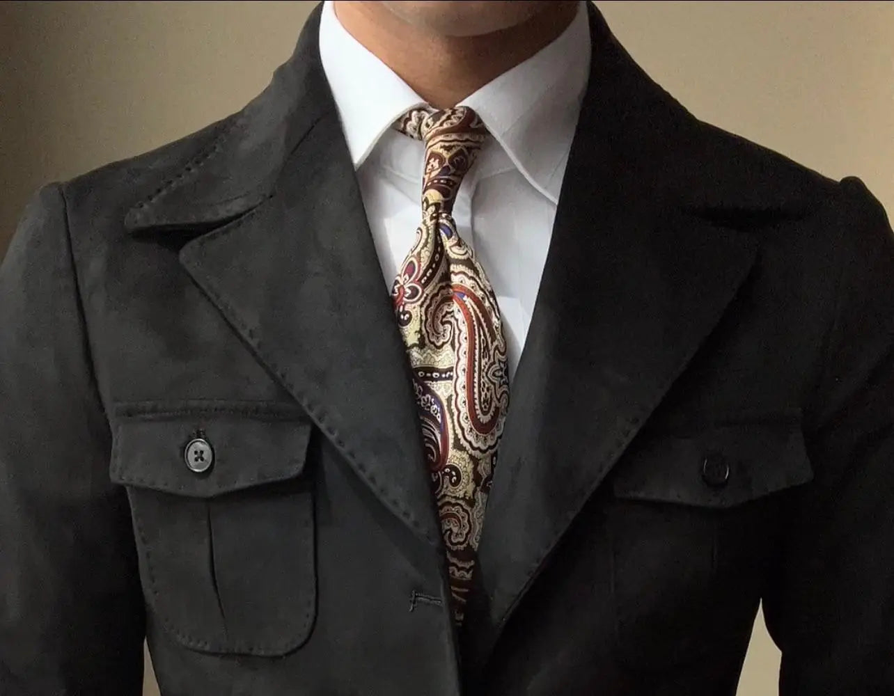 Un blazer de ante gris oscuro con bolsillos de solapa y un cuello solapa, adecuado para un abrigo de terciopelo de ante para hombre retro de primavera color verde oliva.