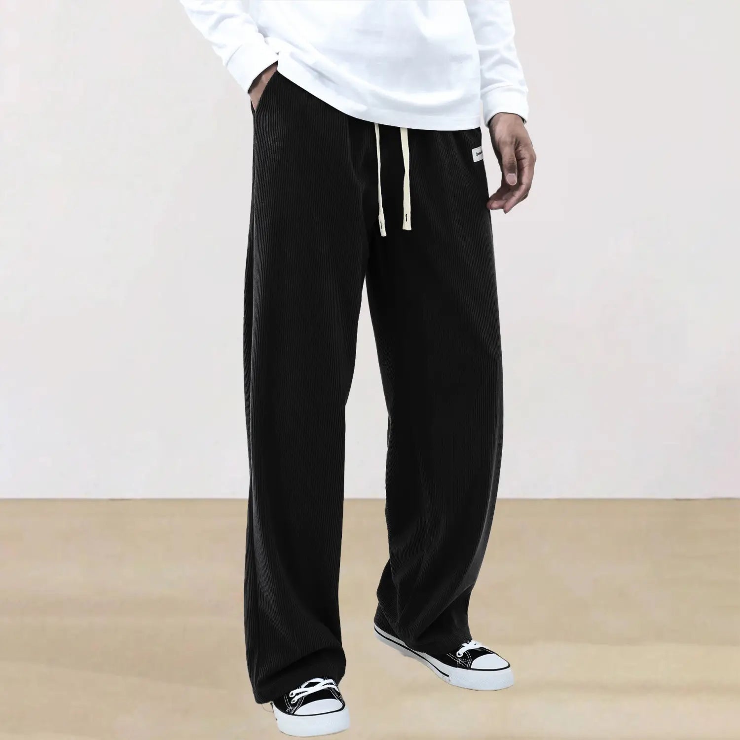 black corduroy wide-leg pants with a drawstring waist and subtle white trim from the men’s slim fit sporty casual pants collection.