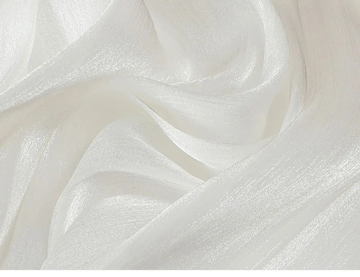 ein zarter irrisierender Chiffon-Faltenrock aus durchsichtigem weißem Seidengewebe mit dezentem Schimmer und weichen Falten