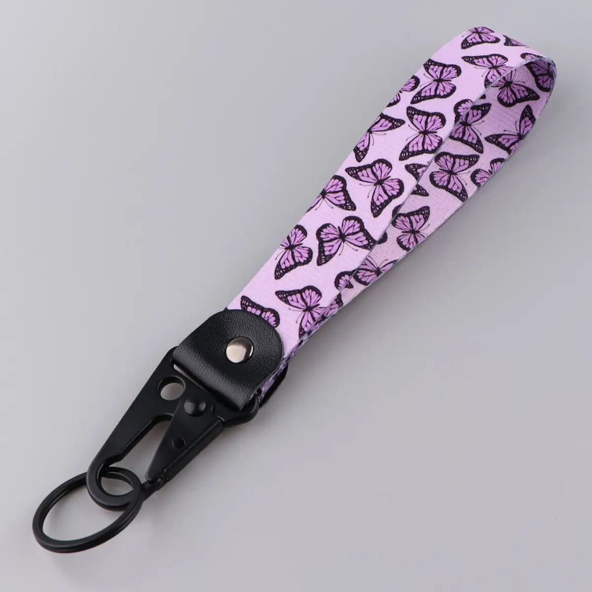 Pink fabric butterfly wrist strap keychain with black butterfly pattern and black metal carabiner clip for secure attachment model tk57