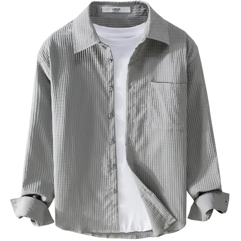 Chemise homme décontractée à manches longues en velours côtelé gris, avec un col classique et une poche poitrine.