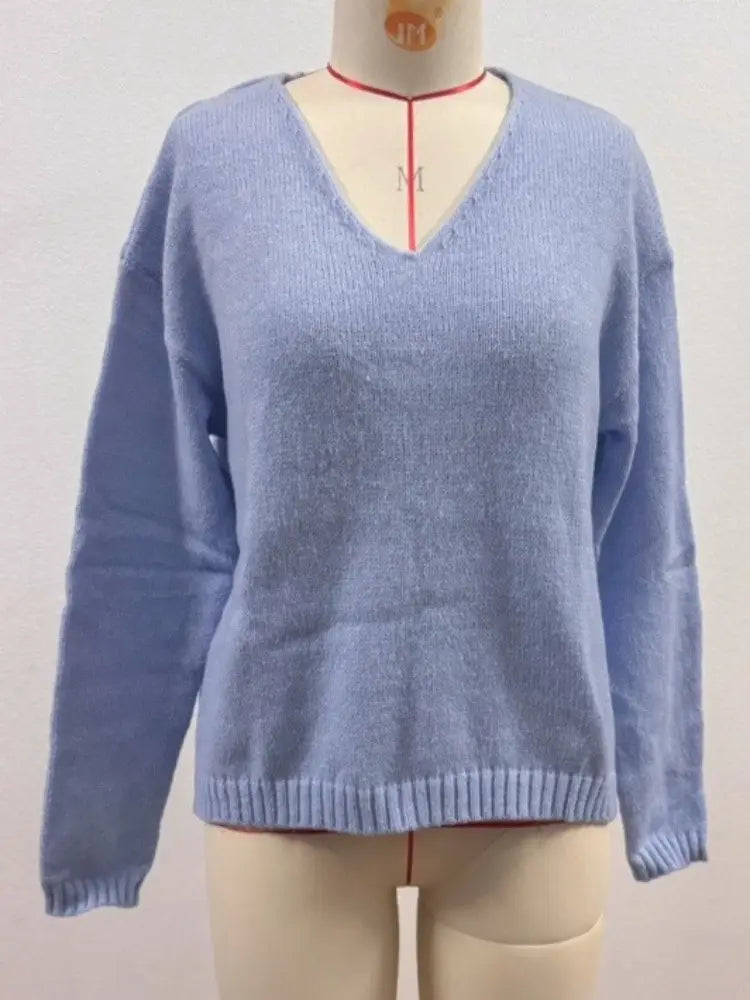 Hellblauer Strickpullover mit weichem Griff, V-Ausschnitt und überschnittener Schulterpartie, mit gerippten Bündchen und Saum.