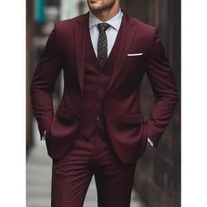 A sharp burgundy men woolen three piece suit with slim fit tailored vest and trousers in smooth fabric for business attire.