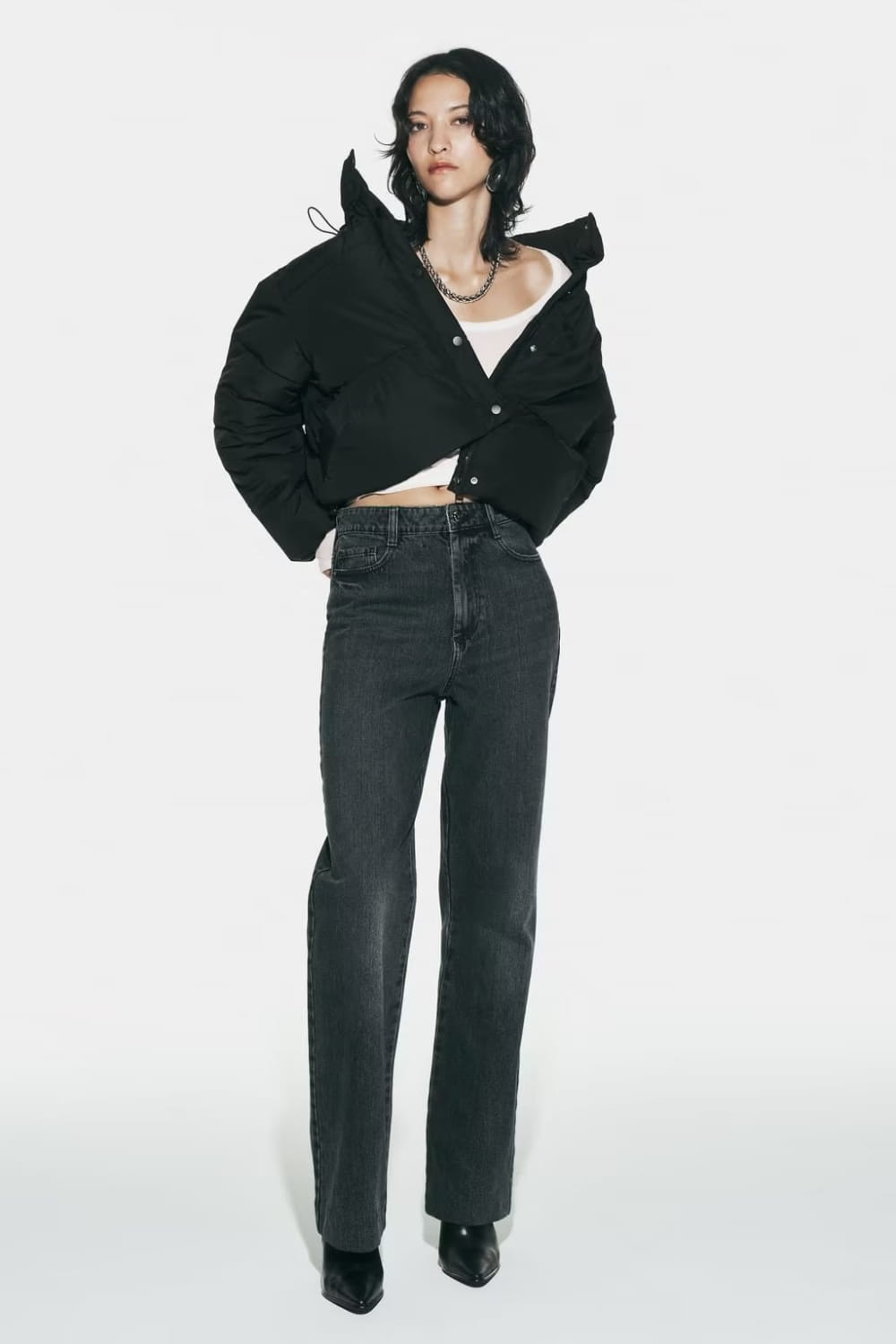 Black quilted hooded puffer coat in black with bold structured collar and button-front design.