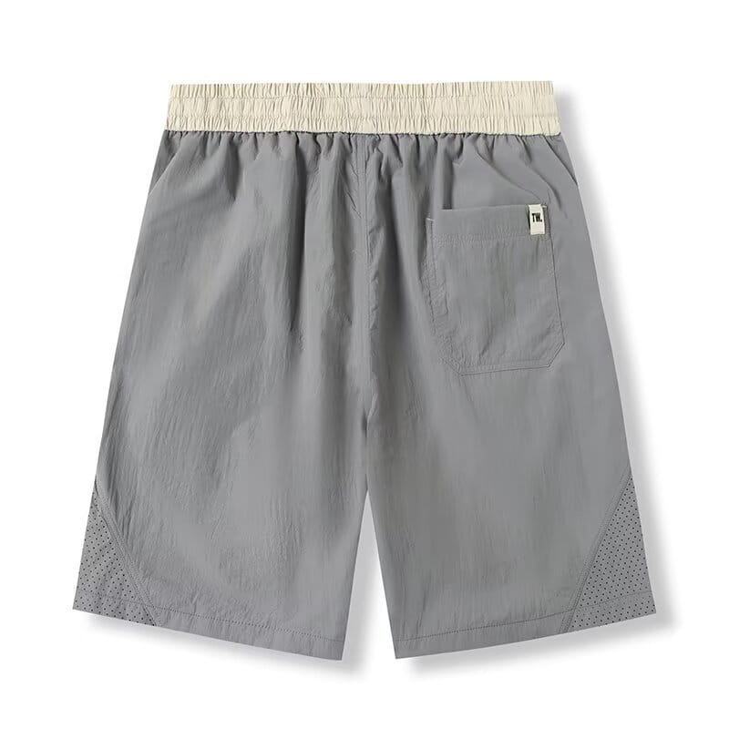 Shorts en nylon décontractés pour hommes, coupe droite, gris, avec une ceinture élastique beige et des panneaux en mesh perforé sur les jambes inférieures.