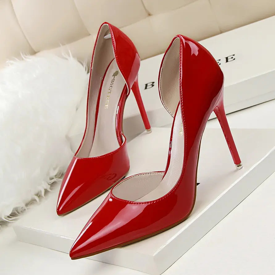 Vibrant red patent leather pointed toe stiletto high heels with a sleek design and thin heels.
