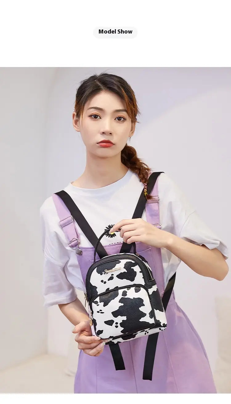Mini backpack featuring black and white cow print with black straps in Korean style.
