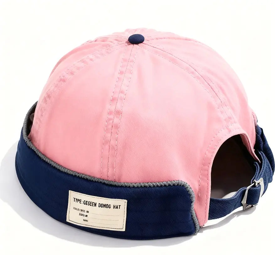 Pink and navy blue canvas fedora hat for men with adjustable denim strap and folded brim featuring a contrasting gray stitched edge and a fabric label reading type geseen domog hat.