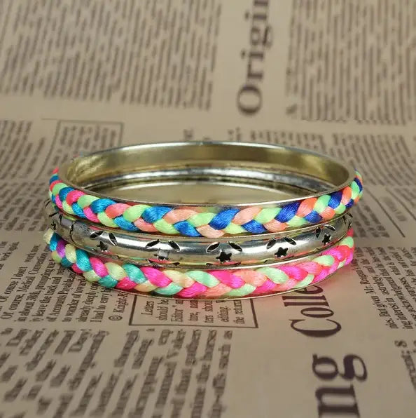 A neon braided gold bangle bracelet set featuring vibrant multicolored neon pink blue and lime green threads wrapped around a silver-toned metal bangle with star accents.