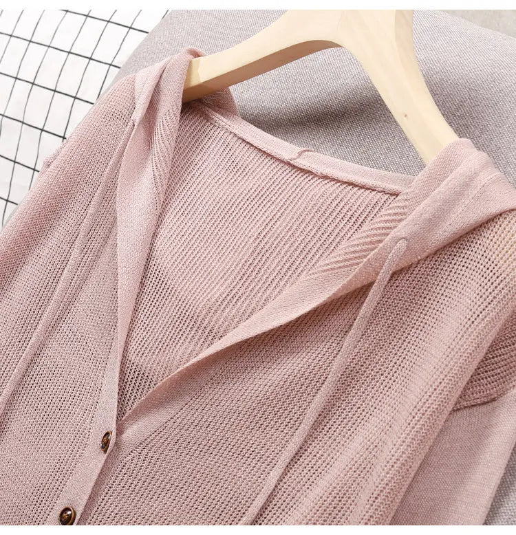 Ein weichrosa gestricktes Hoodie-Cardigan mit offenem Vorderteil, dezenter gerippter Struktur und Knopf-auf-Design.