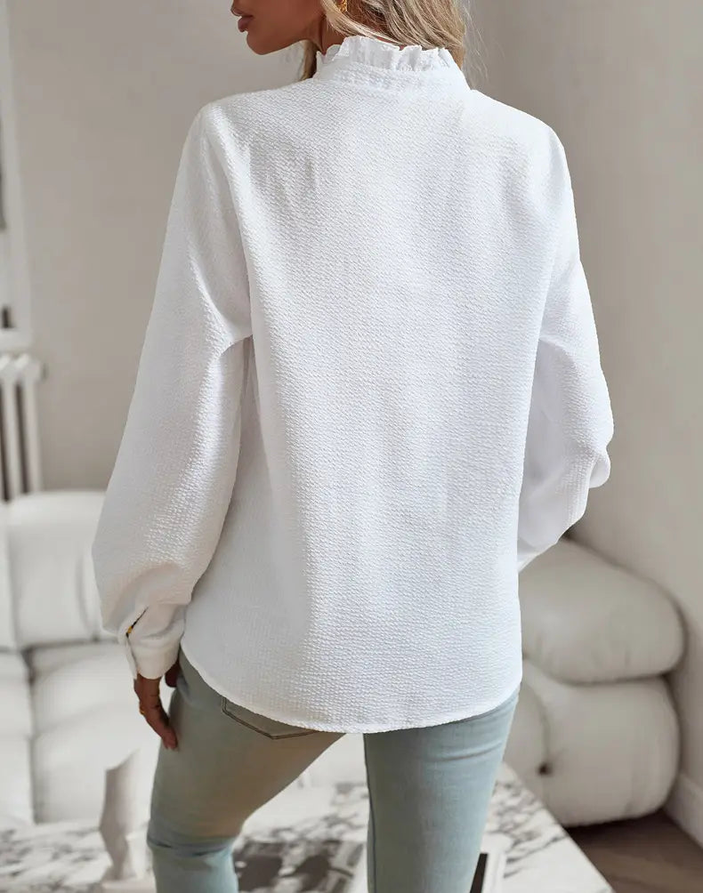 white textured long-sleeved button-up blouse with ruffle trim collar made from lightweight fabric