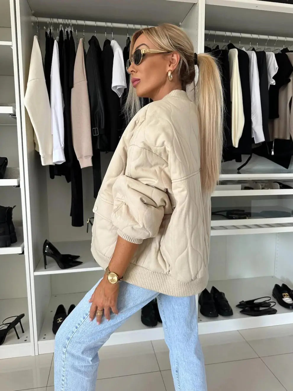 Beige quilted bomber jacket with ribbed cuffs and hem designed as casual outerwear.