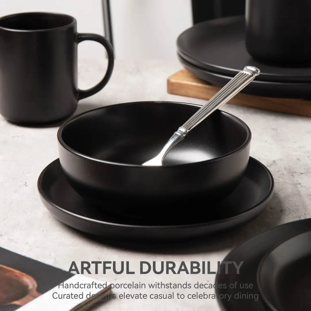 tazón de porcelana mate negro con cuchara de tono plateado en su interior, de un juego de vajilla de gres mate negro de 12 piezas para 3, con diseño minimalista moderno
