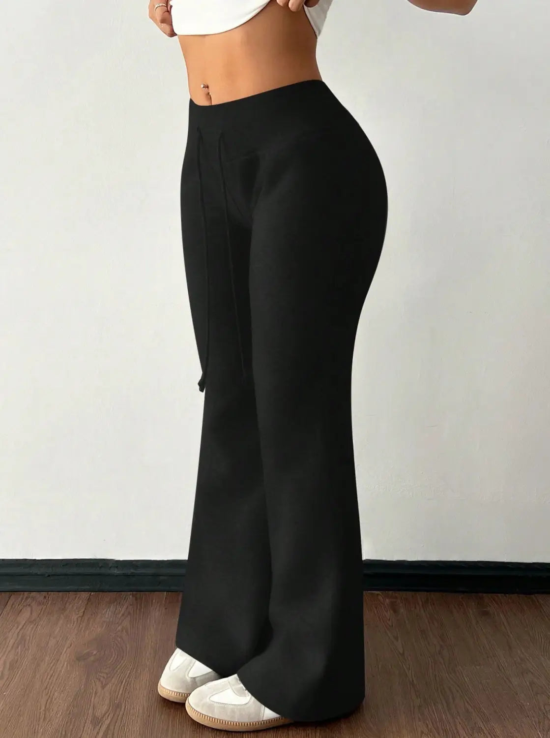 Black fleece lined high waist flared sweatpants with a sleek form fitting silhouette.