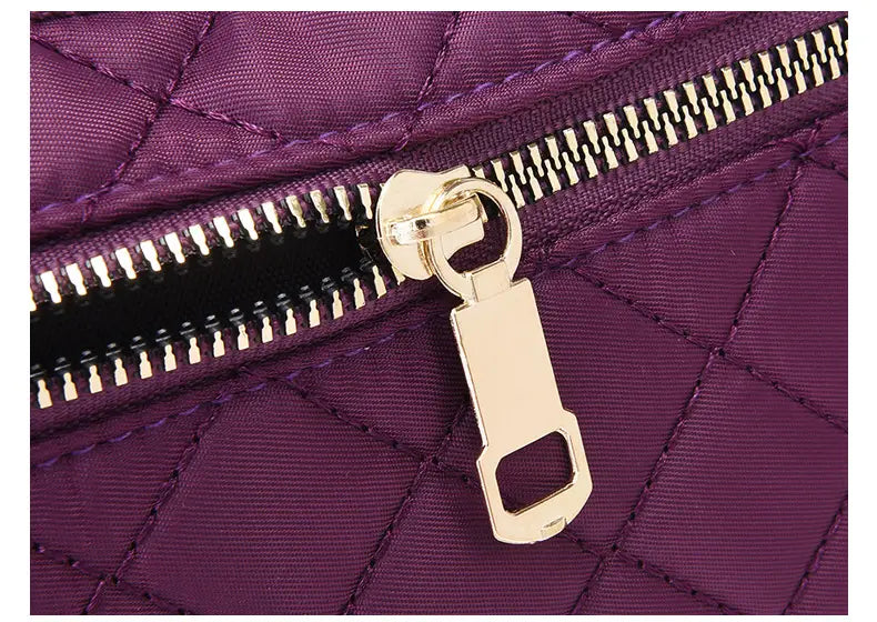 Lila gesteppte Crossbody-Gürteltasche für Damen und Sport mit goldfarbenem Reißverschlusszug und -zähnen.