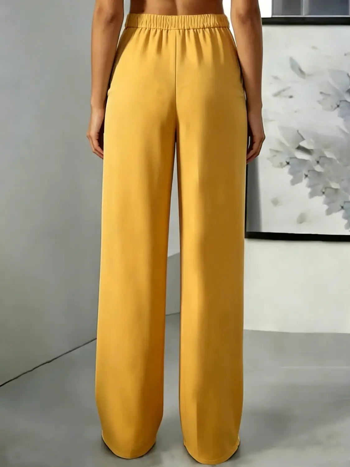 Pantalons à jambes larges jaunes avec une taille haute et une ceinture élastique conçues pour le confort et le style.