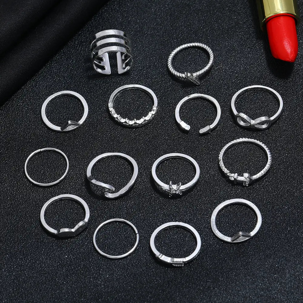 A collection of silver-toned bohemian stackable rings featuring mixed motifs with clear stones and intricate braided and geometric designs.