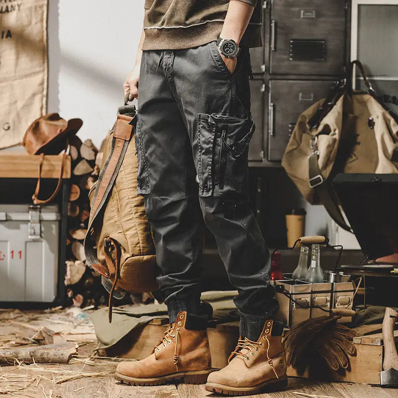 Dark gray men tactical cargo pants with multiple pockets and rugged utilitarian design for outdoor casual utility use.