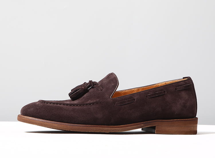 Mocassins à pampilles en daim beige, présentant un matériau en daim brun foncé avec un détail de pampilles et une doublure en cuir beige.