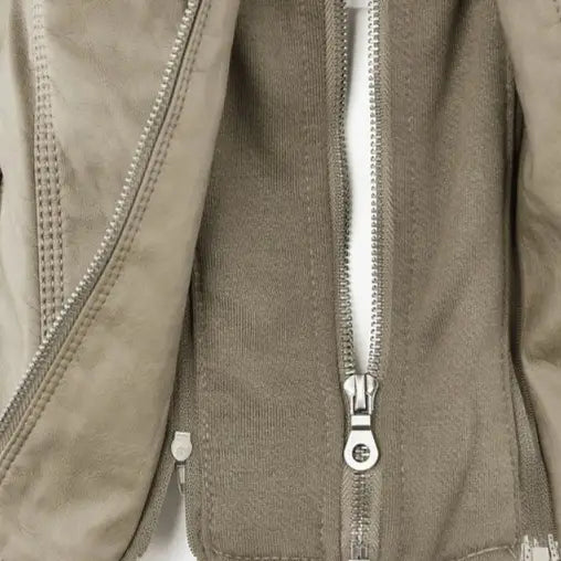 Beige suede faux leather moto jacket with silver zippers and a central front zipper featuring a detachable hood.