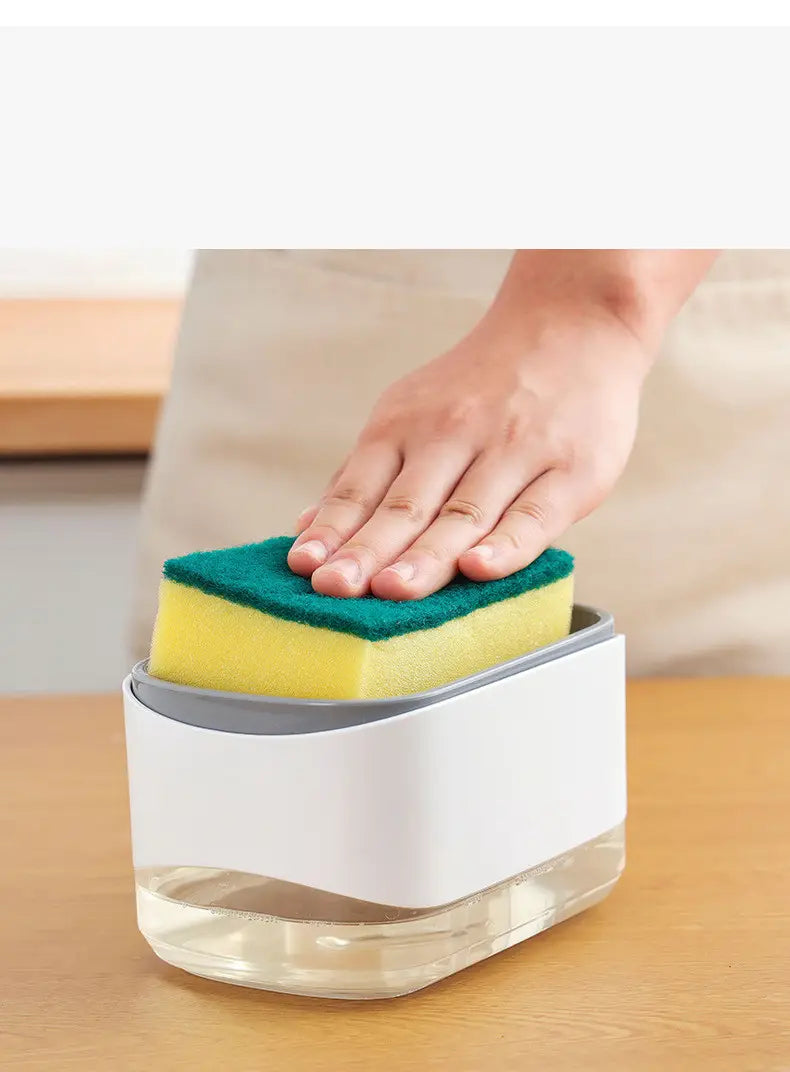 Dispensador de jabón líquido para platos de plástico blanco y gris con capacidad de 350 ml y soporte para esponja integrado, con una esponja de limpieza amarilla y verde apoyada en la parte superior
