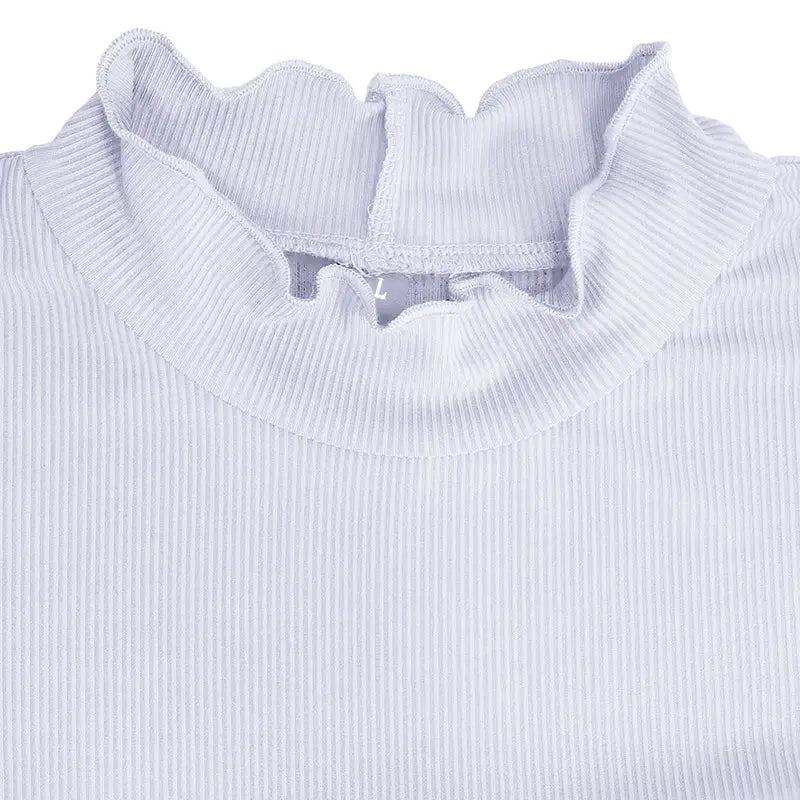 A white ribbed knit slim fit top with a delicate ruffled high neckline for women.