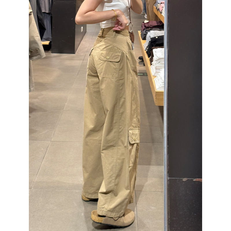 Pantalon cargo femme kaki à taille haute, avec une coupe large ample et plusieurs poches, en matière beige.