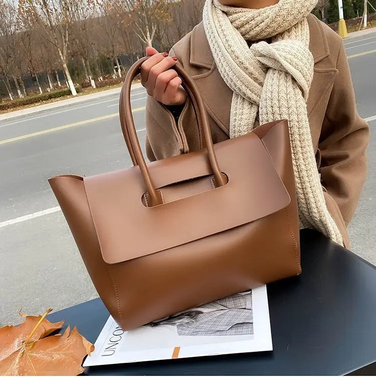 Vintage structured leather tote bag in brown featuring top handles and a minimalist flap closure.