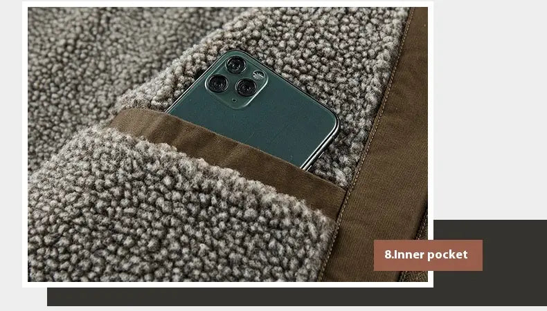 A dark green iphone with a triple-camera system rests in the inner pocket of a gray textured fleece lined winter cotton jacket for men.