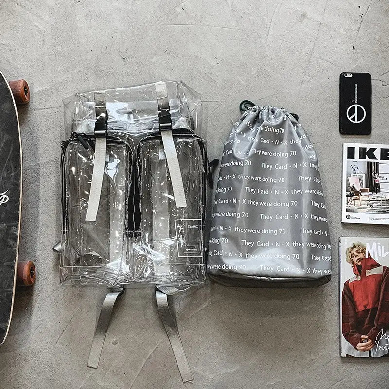 Transparent vinyl text print schoolbag backpack made of clear plastic with black straps and a silver zipper featuring transparent panels on the front pockets.