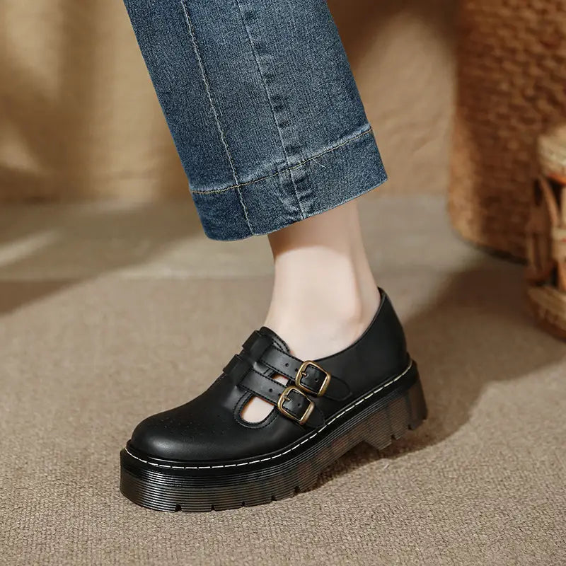 Schwarzer Lederschnürstiefeletten auf Plattform im Brogue-Mary-Jane-Stil mit zwei goldfarbenen Schnallenriemen und einer dicken Plateausohle.