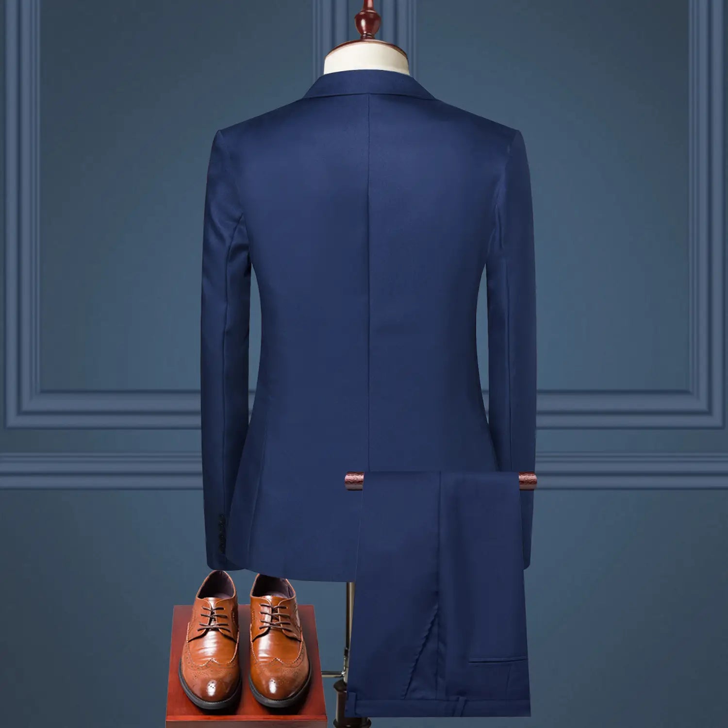 Navy blue tailored men solid color two piece leisure suit with matching trousers paired with brown leather dress shoes.