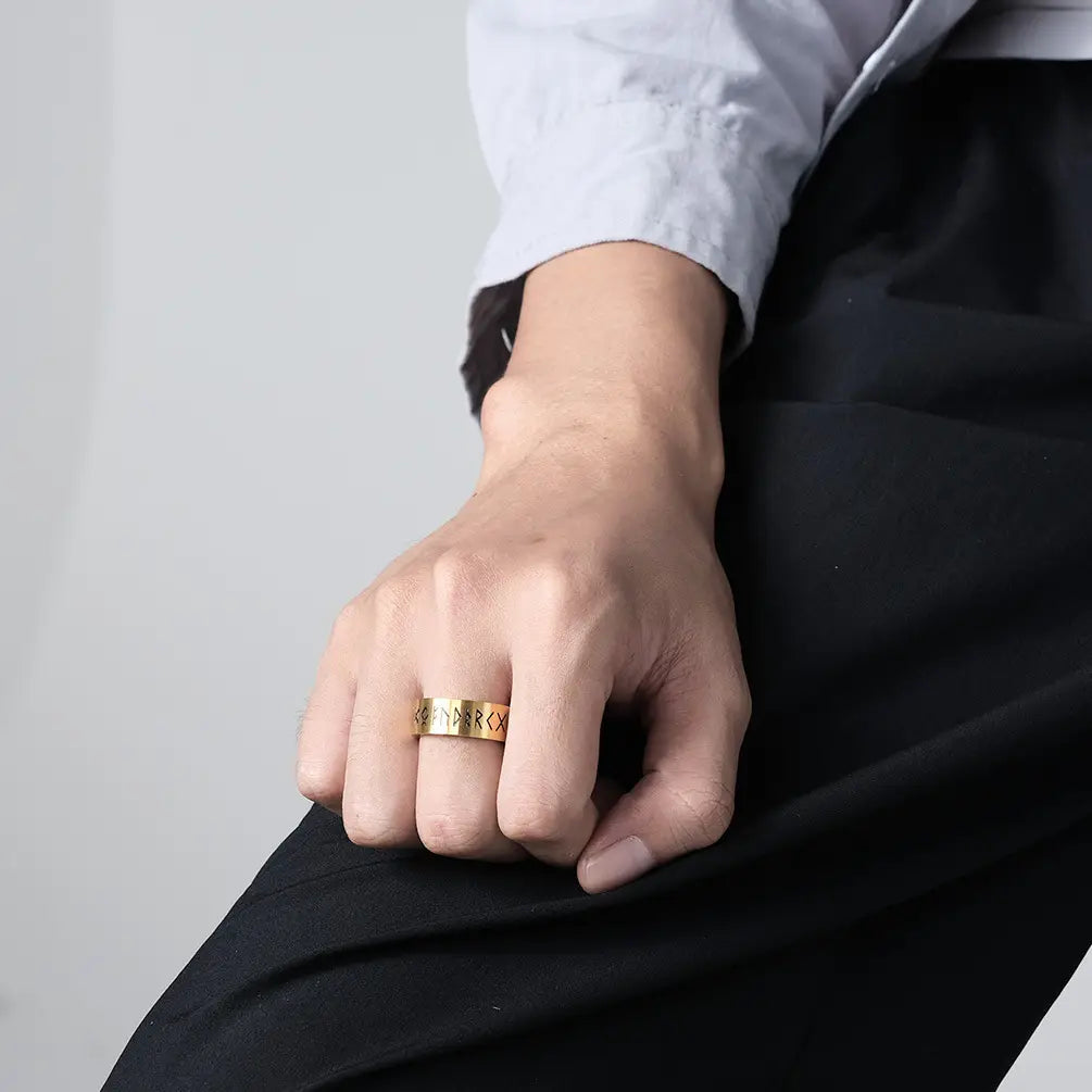 Gold-colored engraved runic titanium steel band ring for men and women showing intricate runes on the outer surface.