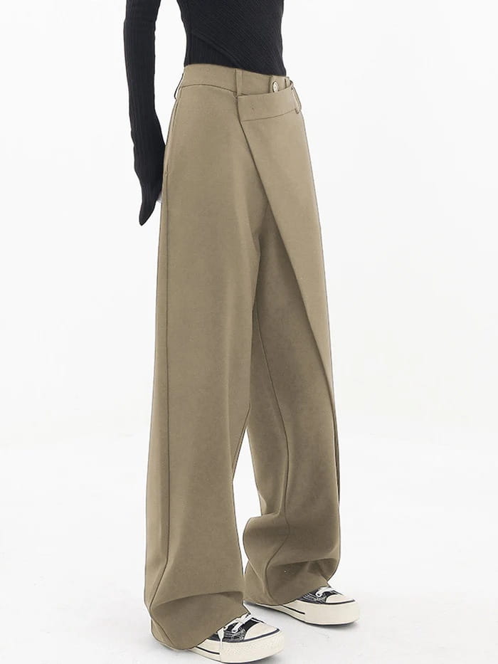 Beige asymmetrische Weitbein-Hosen mit einem schlanken, modernen Schnitt und dezentem Detail mit Vorderfalten.