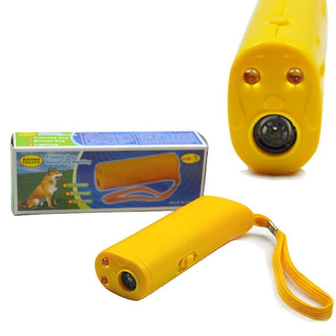 Bright yellow plastic ultrasonic dog trainer with two orange lights, black lens, and wrist strap for barking deterrent use.
