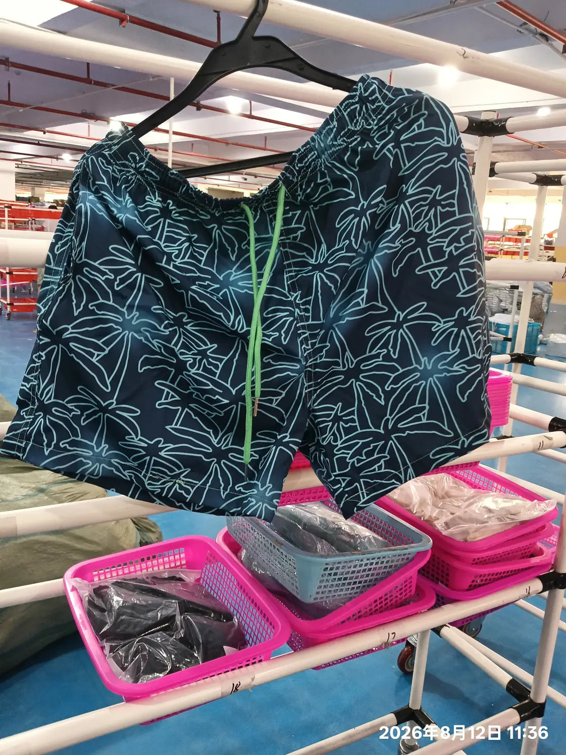 Dark blue printed men beach shorts featuring light blue palm tree outlines and a bright green drawstring designed for summer swim trunks.
