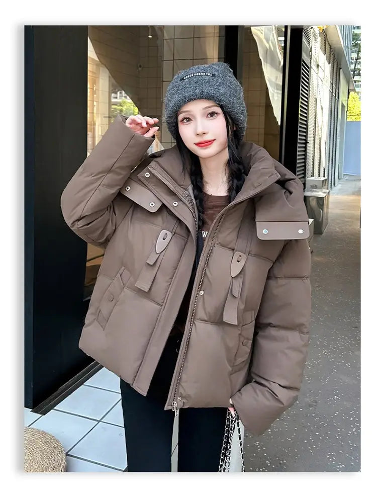 Veste courte matelassée à capuche pour femme beige clair, confortable, avec un design matelassé et plusieurs poches à rabat pour l’habillement d’hiver chaud.