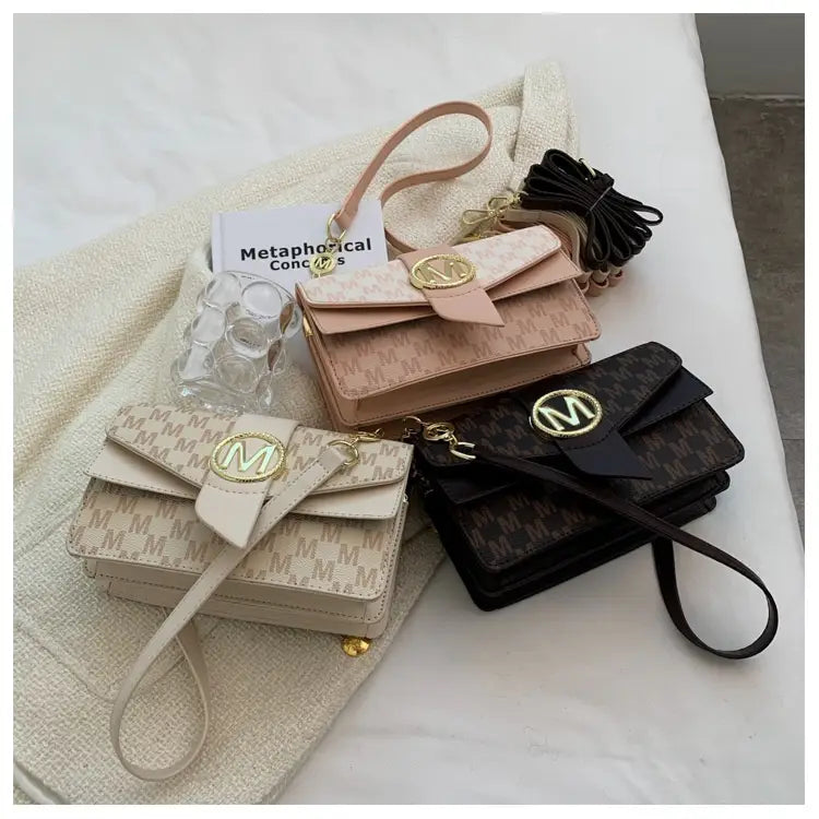 beige and black patterned leather mini crossbody messenger bags with gold-tone m logo hardware and monogram letter print design
