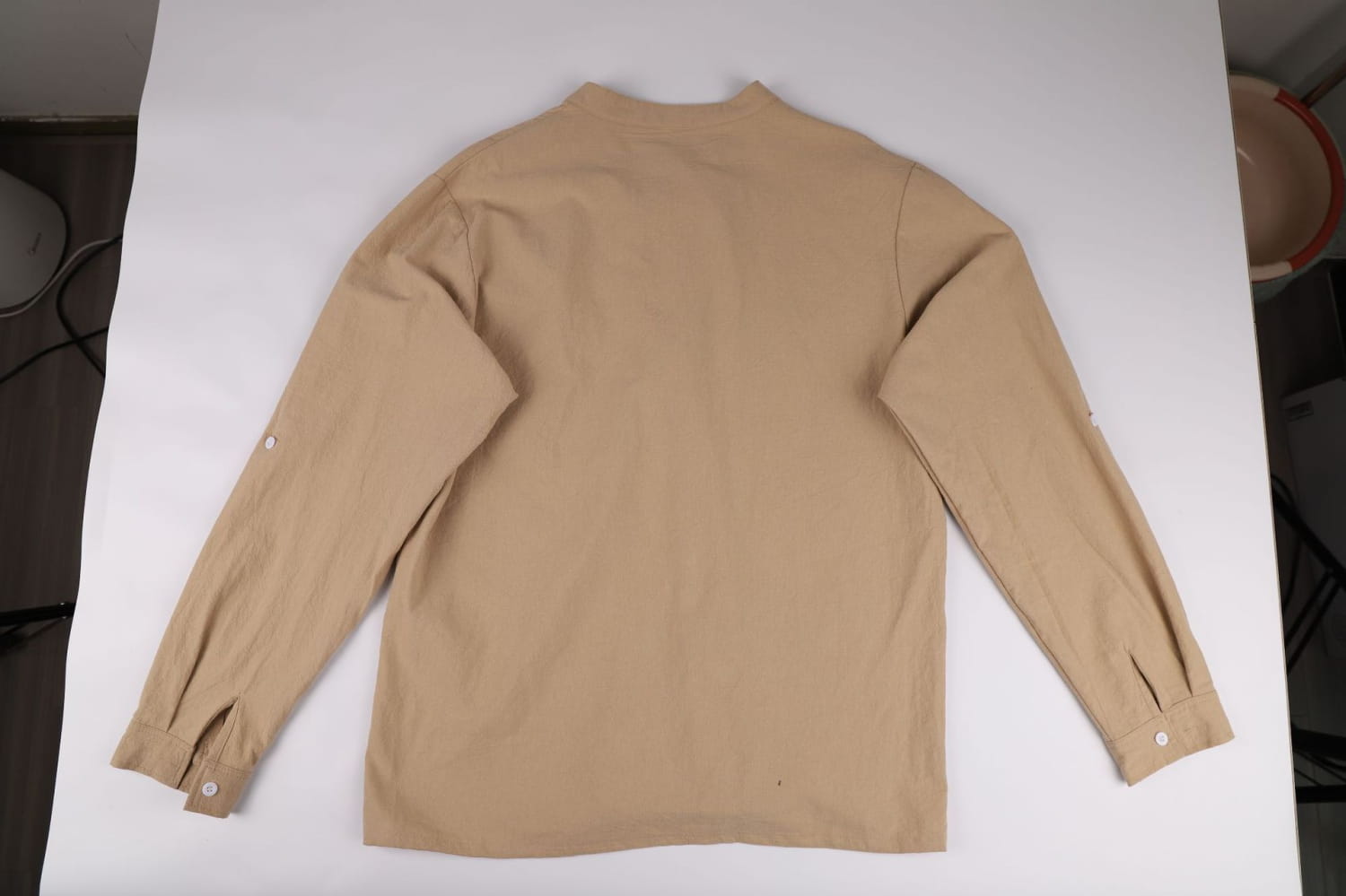 Camisa tipo henley de lino color beige para hombre, de manga larga, con frente con cordones, cuello clásico y puños acabados con esmero, diseñada para mangas arremangables.
