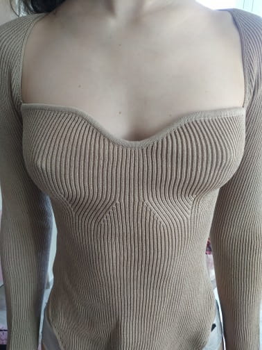 Beige ribbed knit pullover with a square neckline and structured bodice featuring long sleeves.