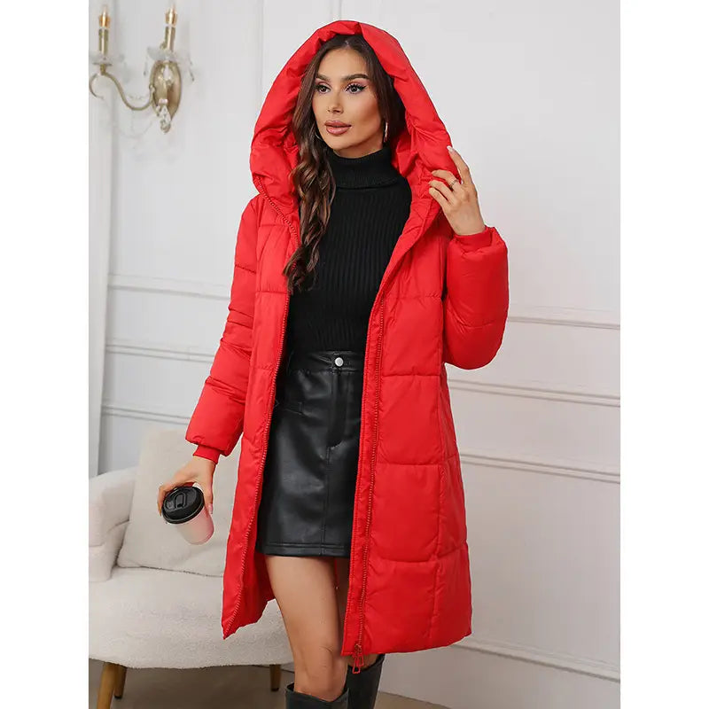 A vibrant red long cotton padded winter jacket for women with a hood and quilted design.