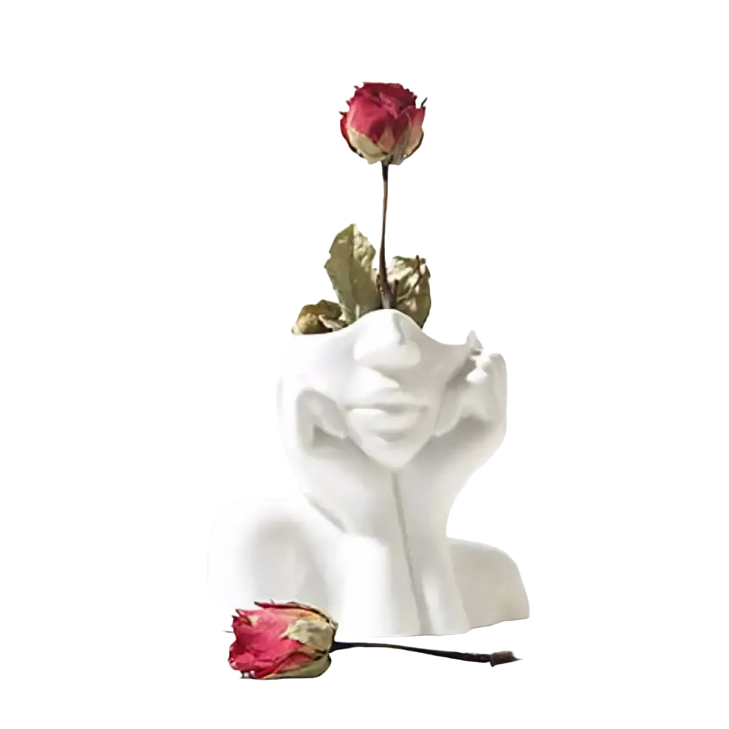 White ceramic abstract face makeup brush holder and vase with hand resting on cheek holding dried red rose