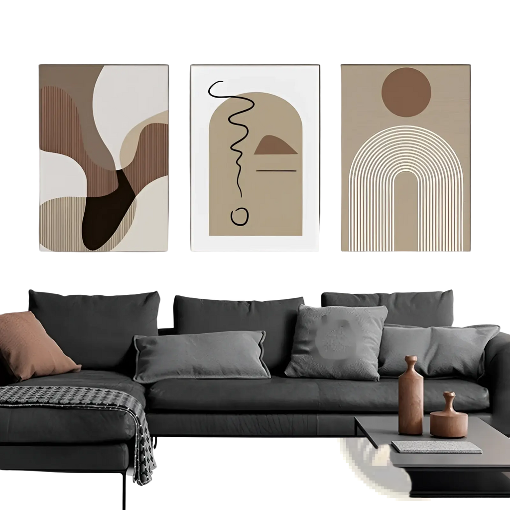 Three minimalist abstract wall art canvas prints in earthy beige brown and cream tones displayed above gray sofa