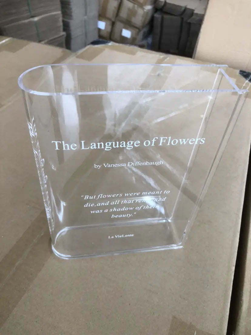 pisapapeles de acrílico transparente con texto grabado de El idioma de las flores de Vanessa Diffenbaugh, utilizado como jarrón de flores de decoración moderna para el hogar.