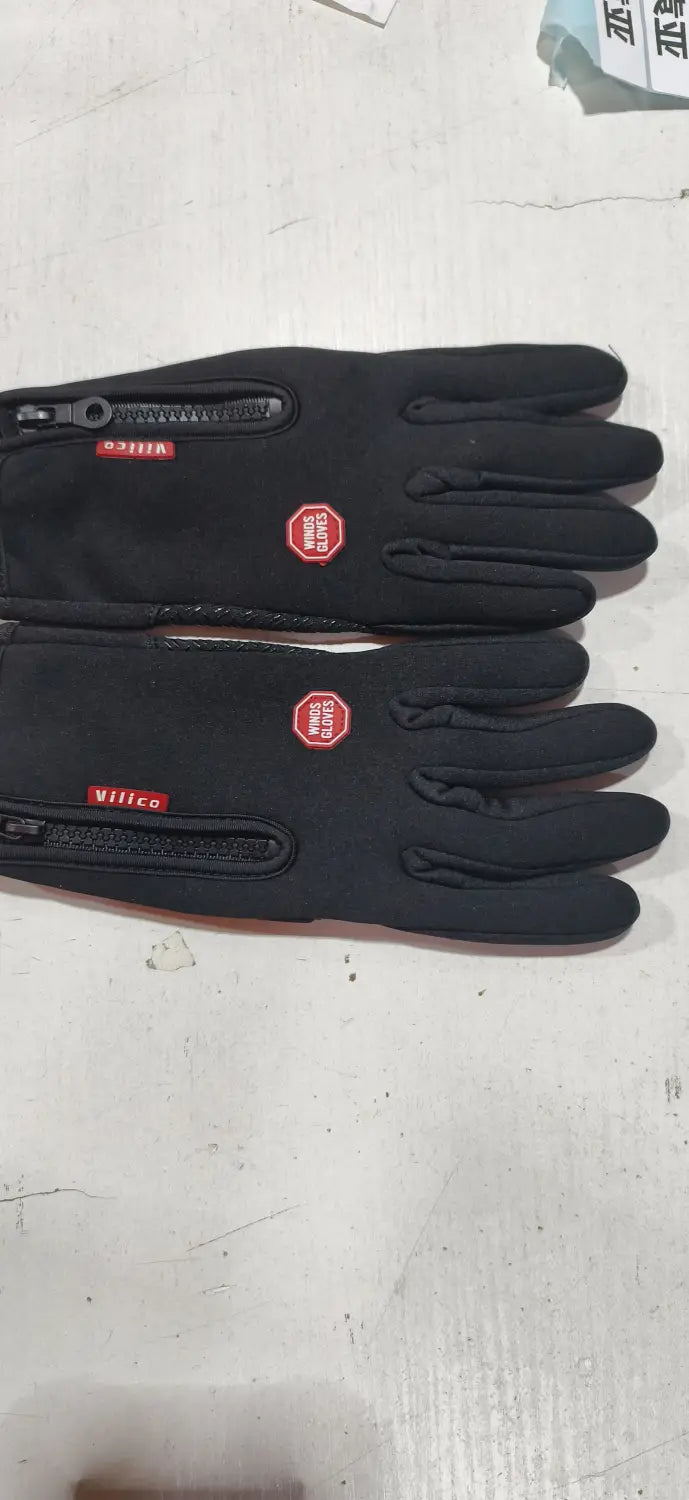 Black velica windproof touchscreen winter gloves for men and women shown from the back side with red zipper pulls and a small circular logo on each hand.